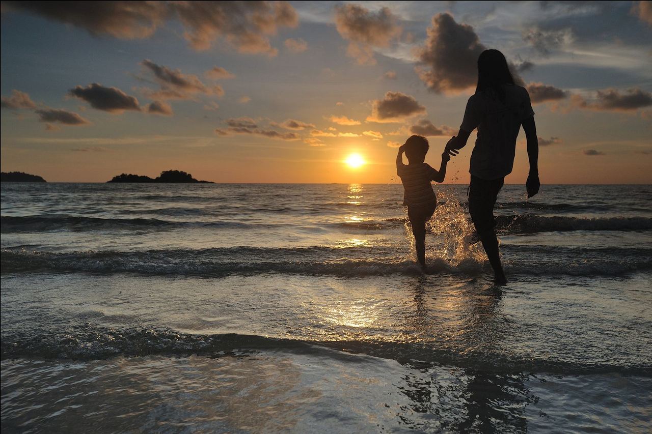 Family walking on a South Florida beach at sunset